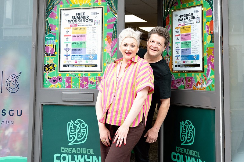 Libby & Stuart Loughland smiling by the front door of Creadigol Colwyn Creative