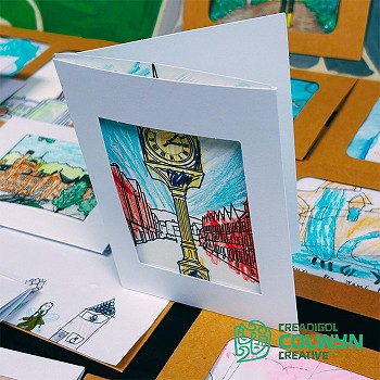 Close view of a card that has a clock in the middle and a street in the background